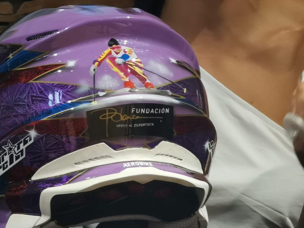 Primer plano del casco de competición de Sara García, con la imagen de una esquiadora y el logo de la Fundación Blanca como homenaje a Blanca Fernández-Ochoa.